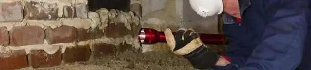 Pest control technician inspecting a crawl space for ant activity and entry points in Bloomington, IN