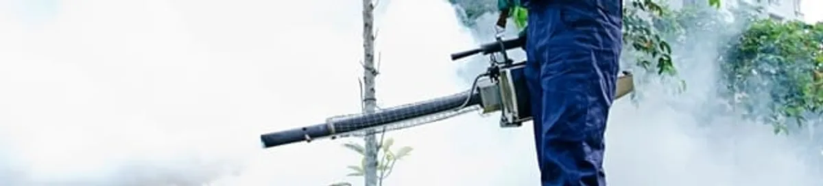 Pest control technician fogging an outdoor area for insect control in Bloomington, IN
